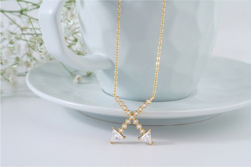 Free A luxurious gold necklace adorned with diamonds elegantly draped over a ceramic cup. Perfect for jewelry enthusiasts. Stock Photo