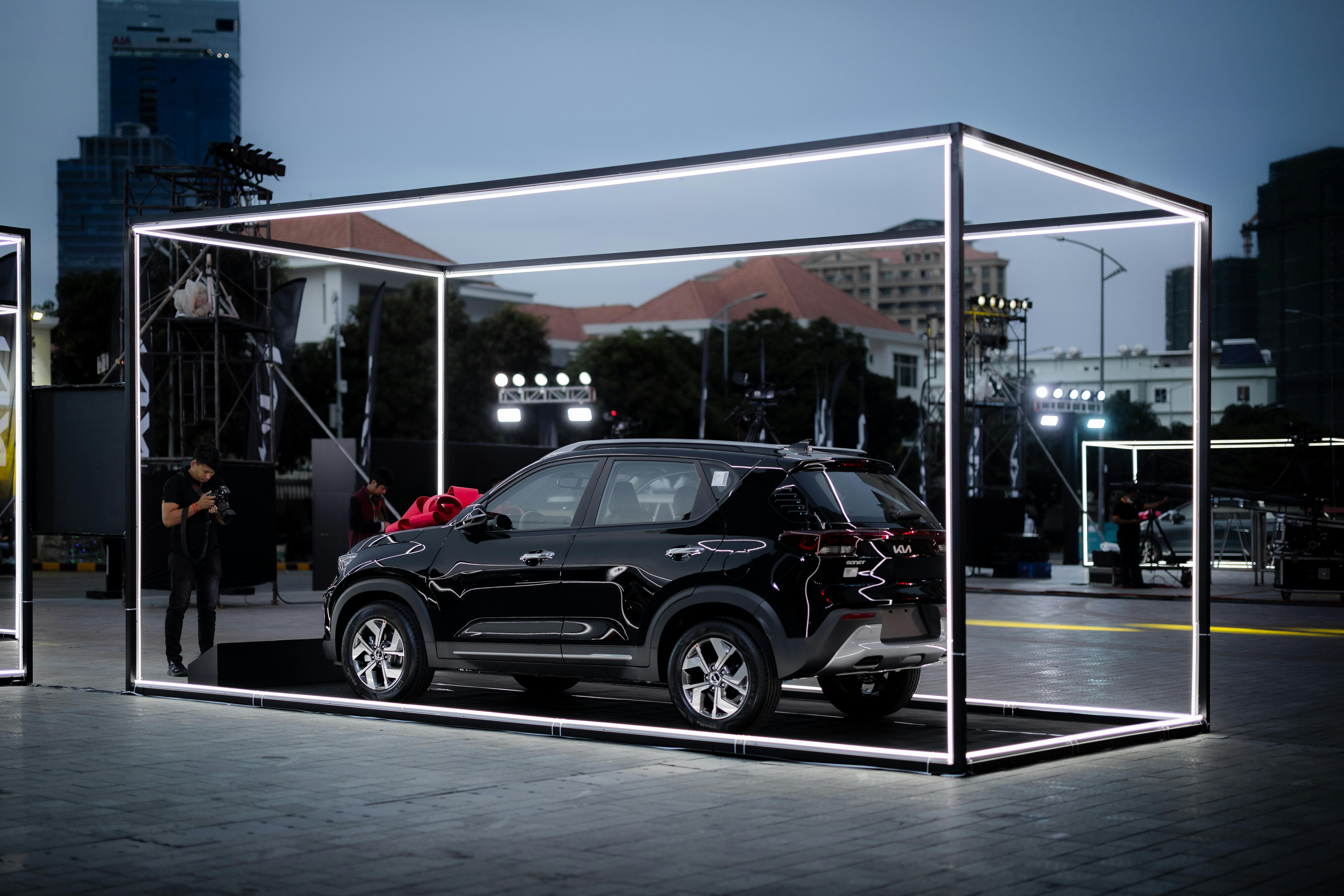 Automotive manufacturer's trade show display with car model and presenter