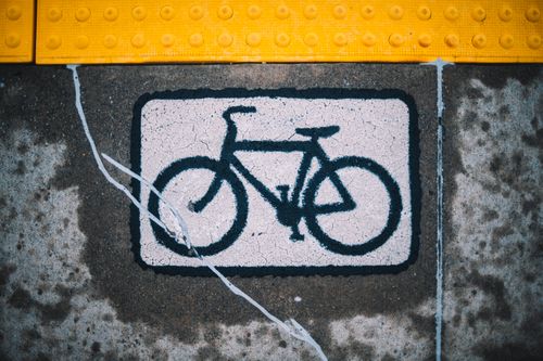 Free Detailed view of a bicycle lane sign painted on concrete with tactile paving. Stock Photo