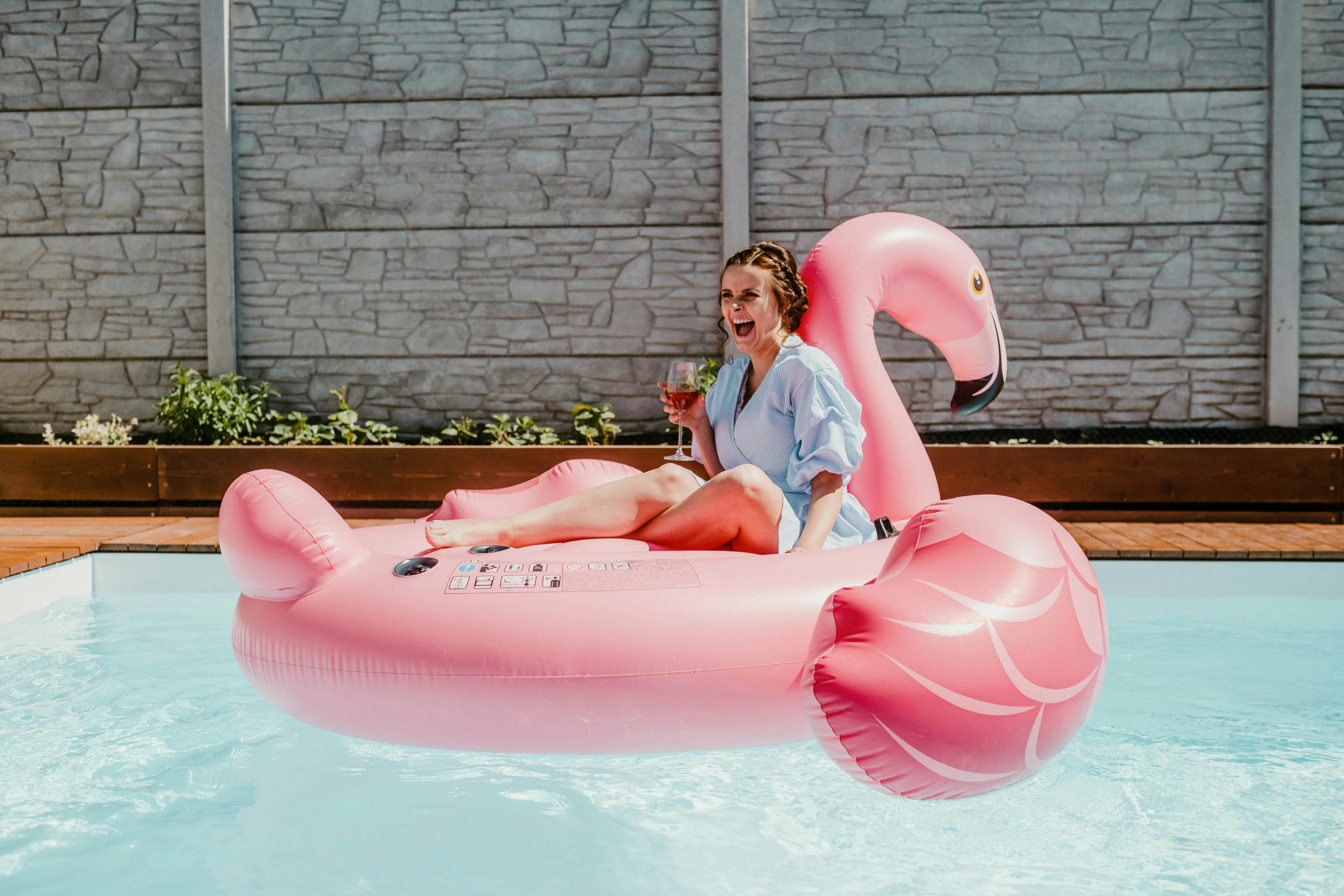 A Woman Sitting on a Flamingo Pool Float · Free Stock Photo