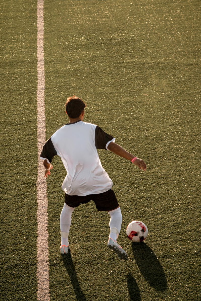 Pemain menggiring bola di lapangan