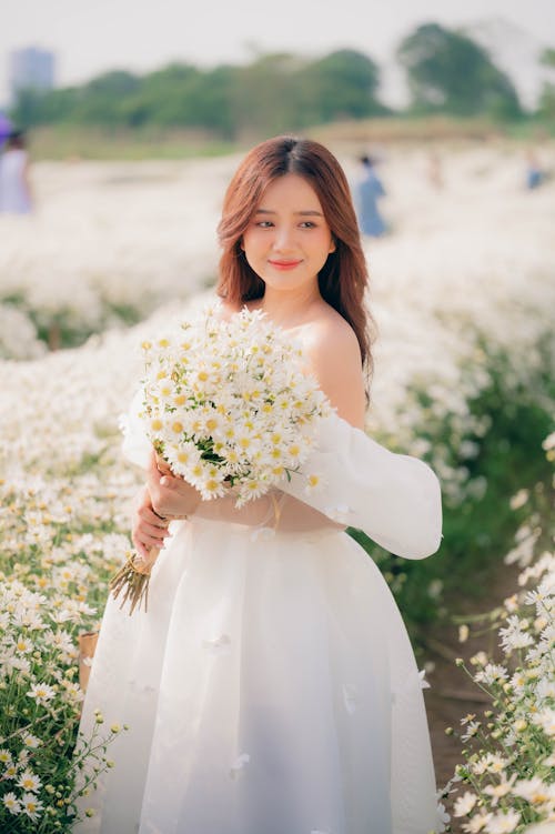 Young Bride Holding a Bouquet on a Field 