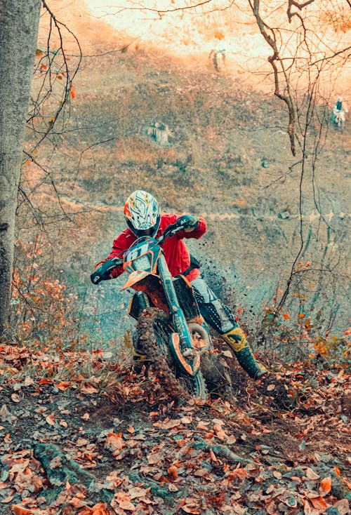 A Person in Red Jacket Riding a Dirt Bike at the Forest