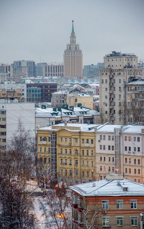 Free A stunning aerial view of a cityscape in winter with snow-covered rooftops. Stock Photo