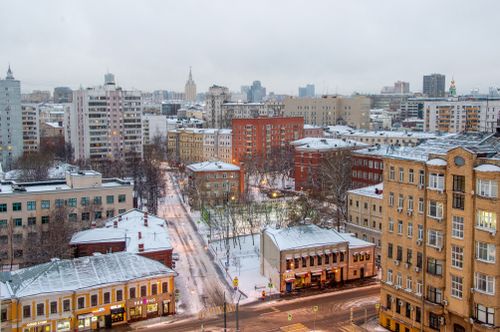Free Aerial view of a city with snow-covered streets and buildings in winter. Stock Photo