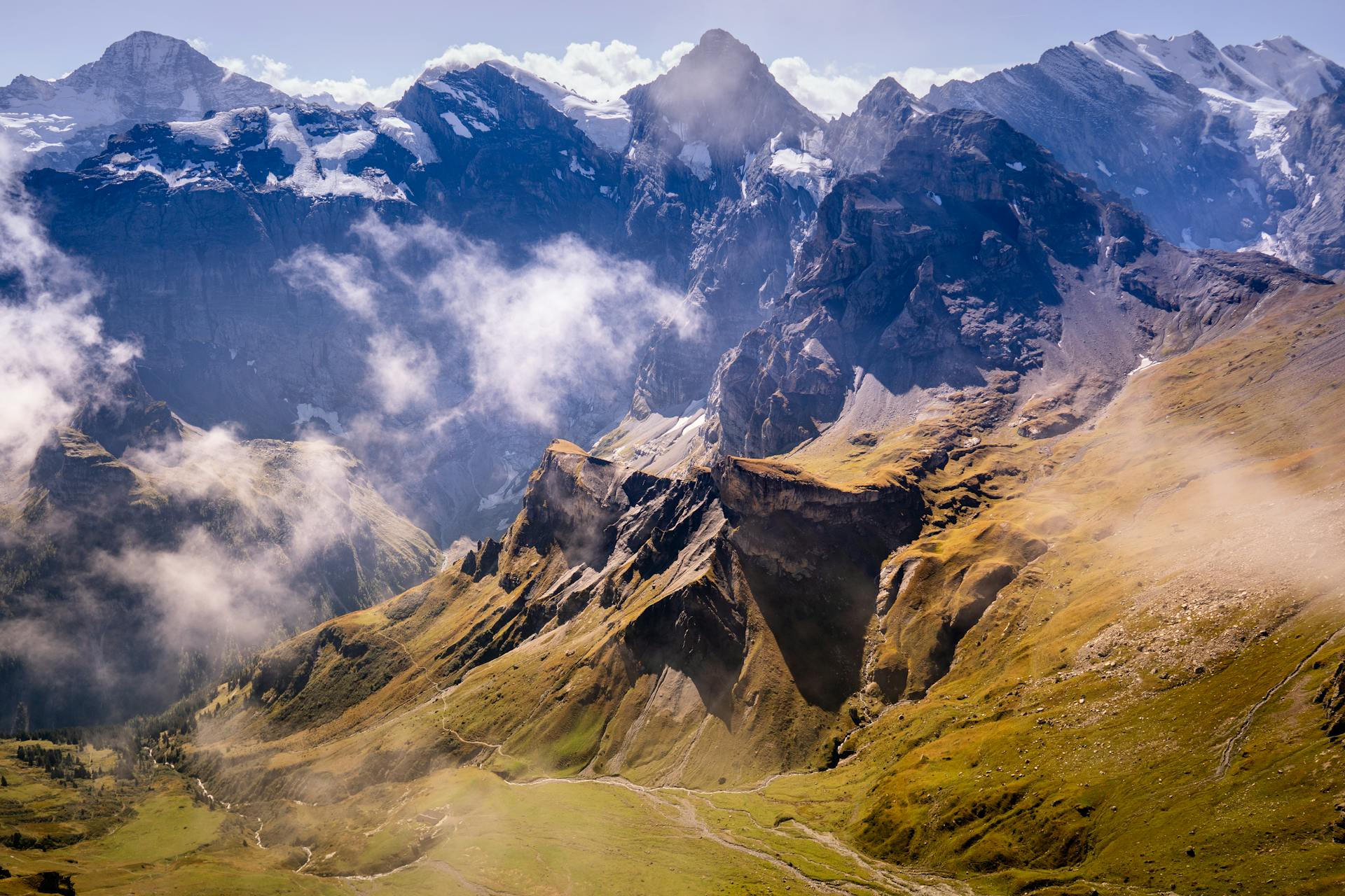 Breathtaking aerial shot of the magnificent Lauterbrunnen mountains in Switzerland with floating clouds.