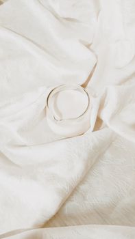A delicate minimalist shot of a glass of milk on textured white fabric, highlighting simplicity.