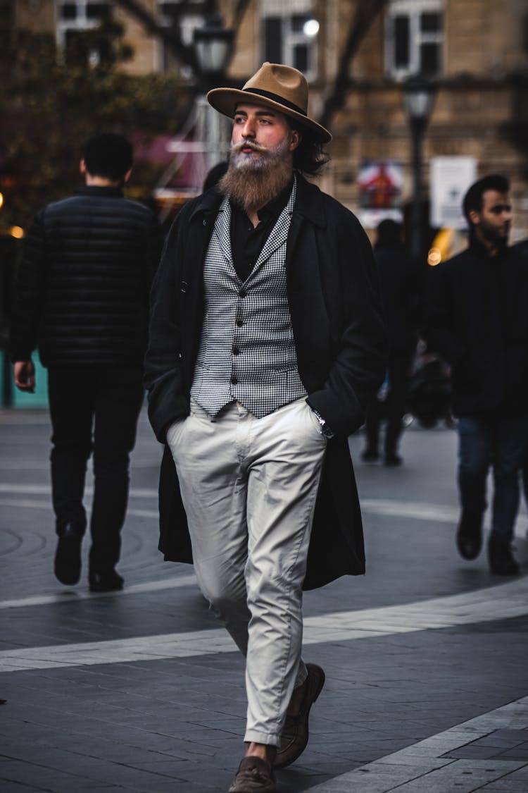 A Bearded Man In Black Coat Walking On The Street