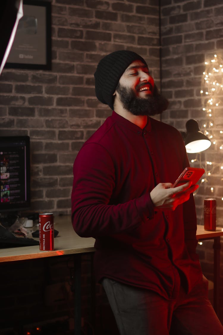 A Man Laughing And Holdin A Smart Phone