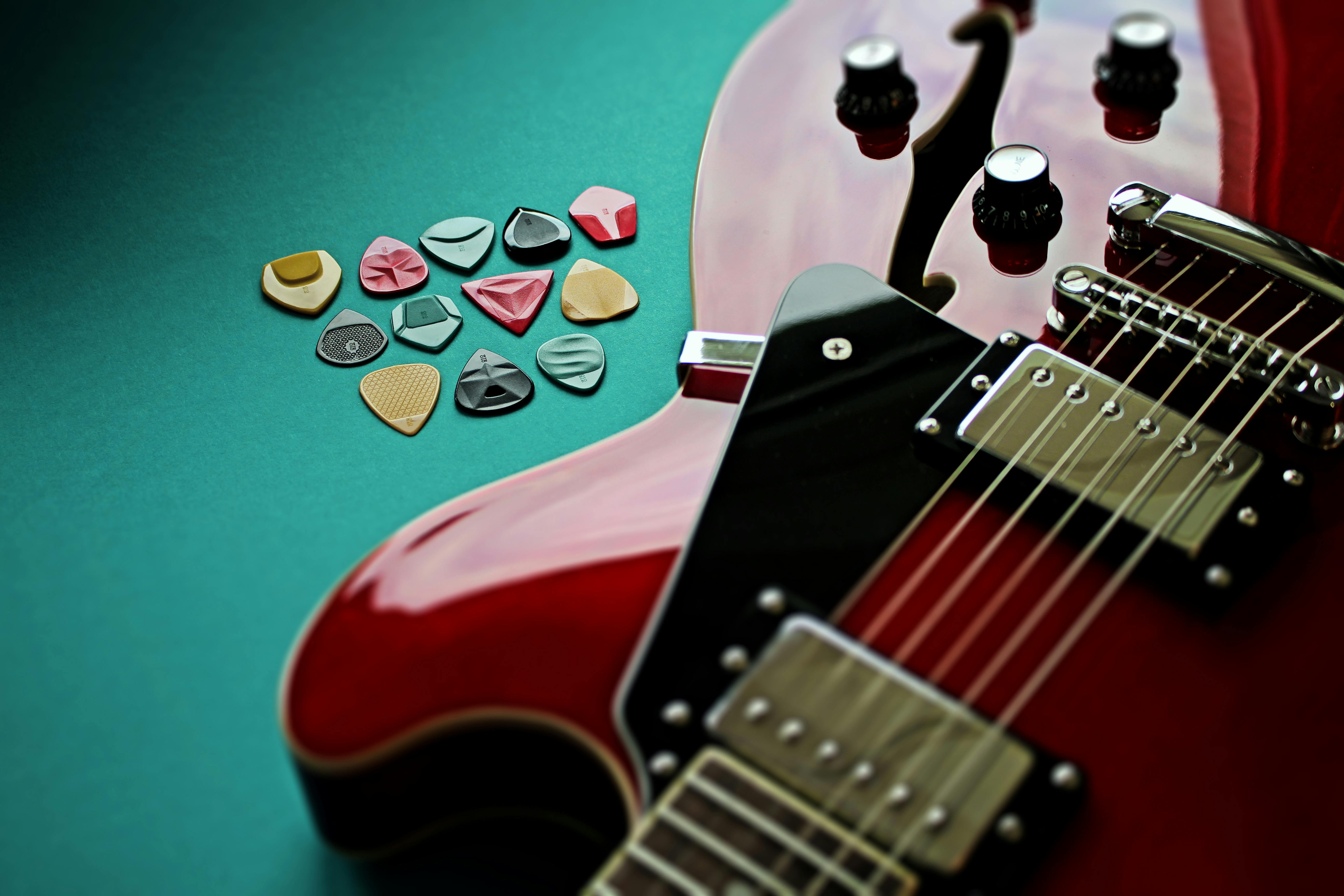 Guitar Picks and Red Electric Guitar · Free Stock Photo