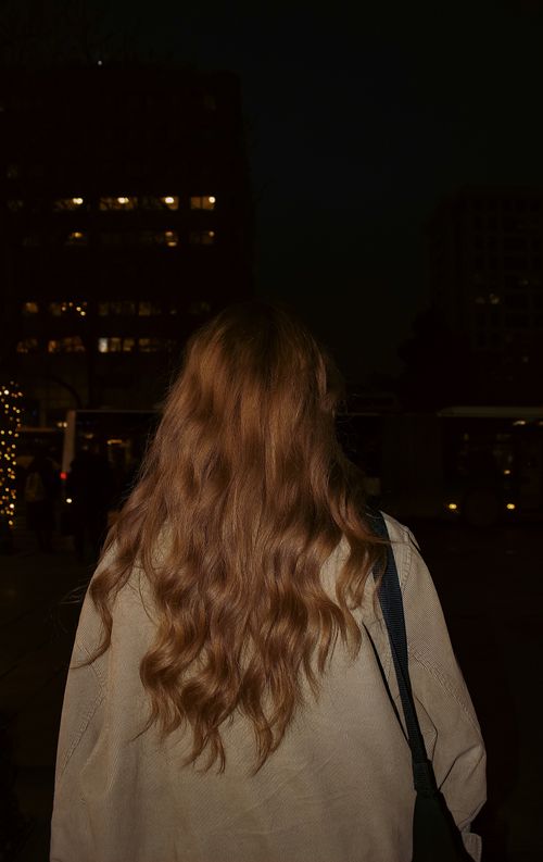 Free Woman with curly hair walks through Ankara at night, exploring the cityscape. Stock Photo