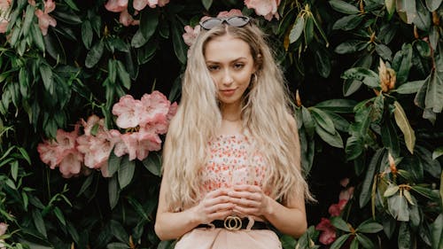 Free Woman Standing Against Flowers Stock Photo