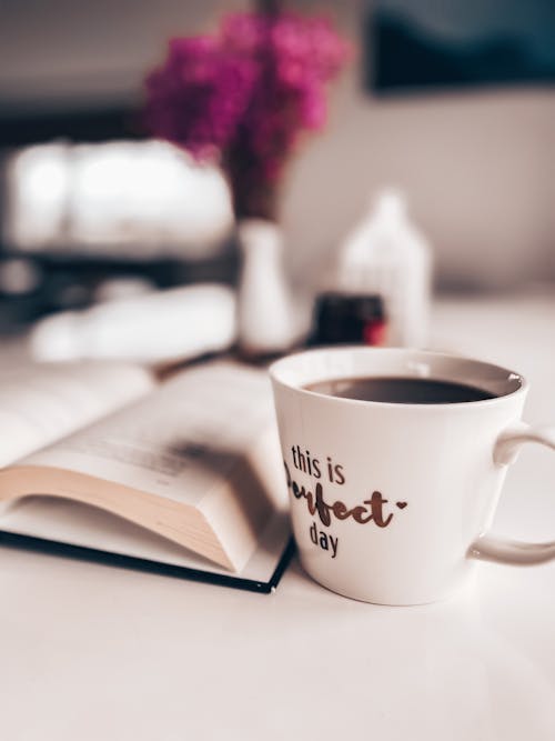 Free Cup of Coffee Beside a Book Stock Photo