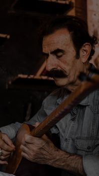 Senior man playing a traditional string instrument in Gaziantep, Turkey.