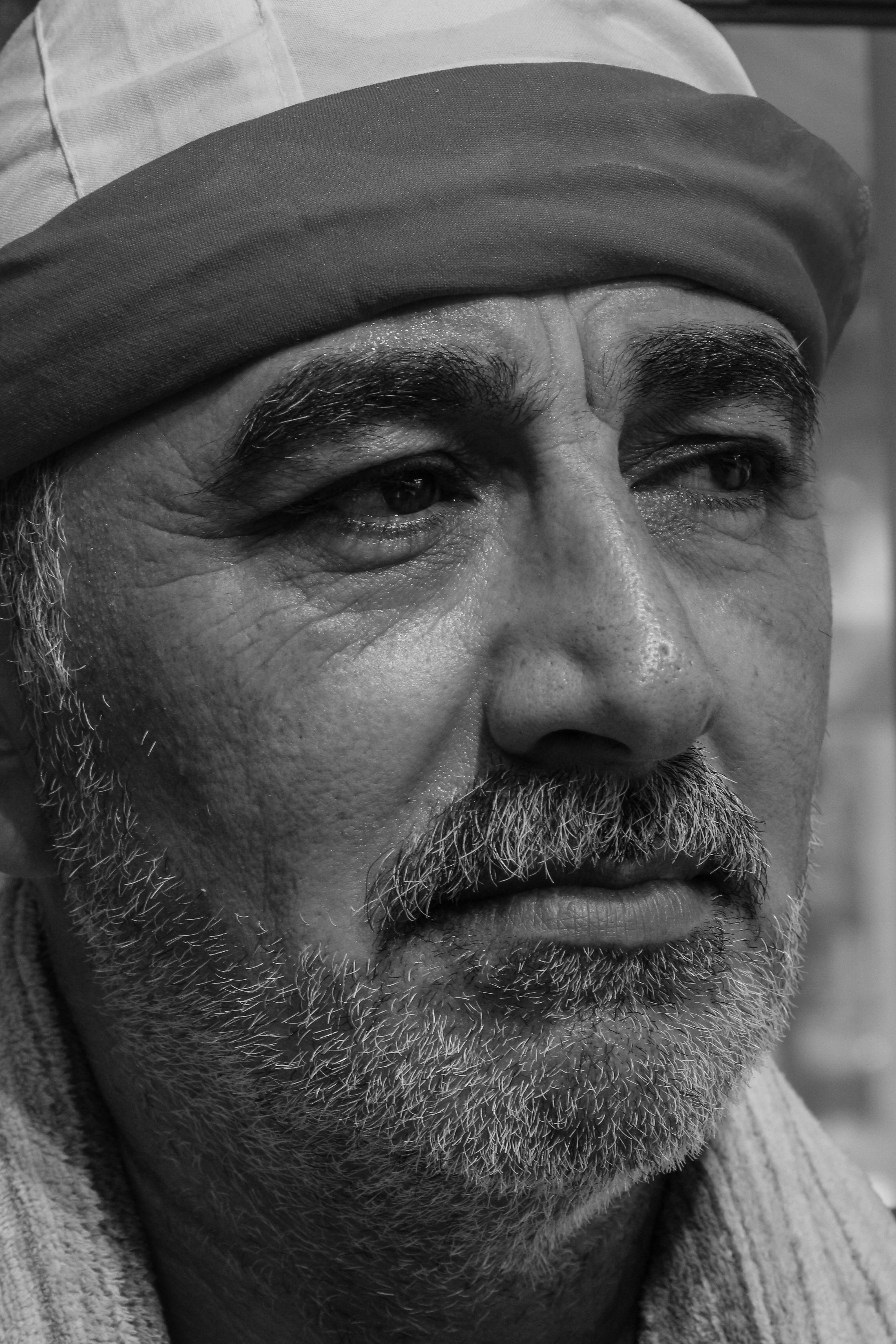Close-up black and white portrait of a middle-aged bearded Middle Eastern man in Istanbul, Turkey.