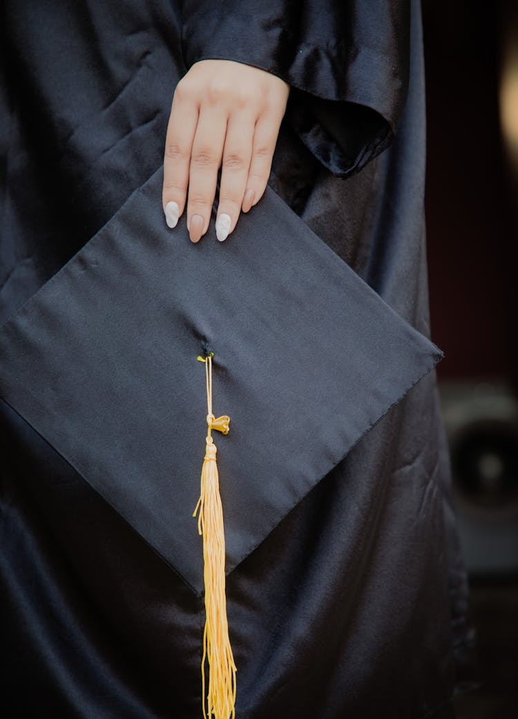 Hand Holding A Graduation Cap 