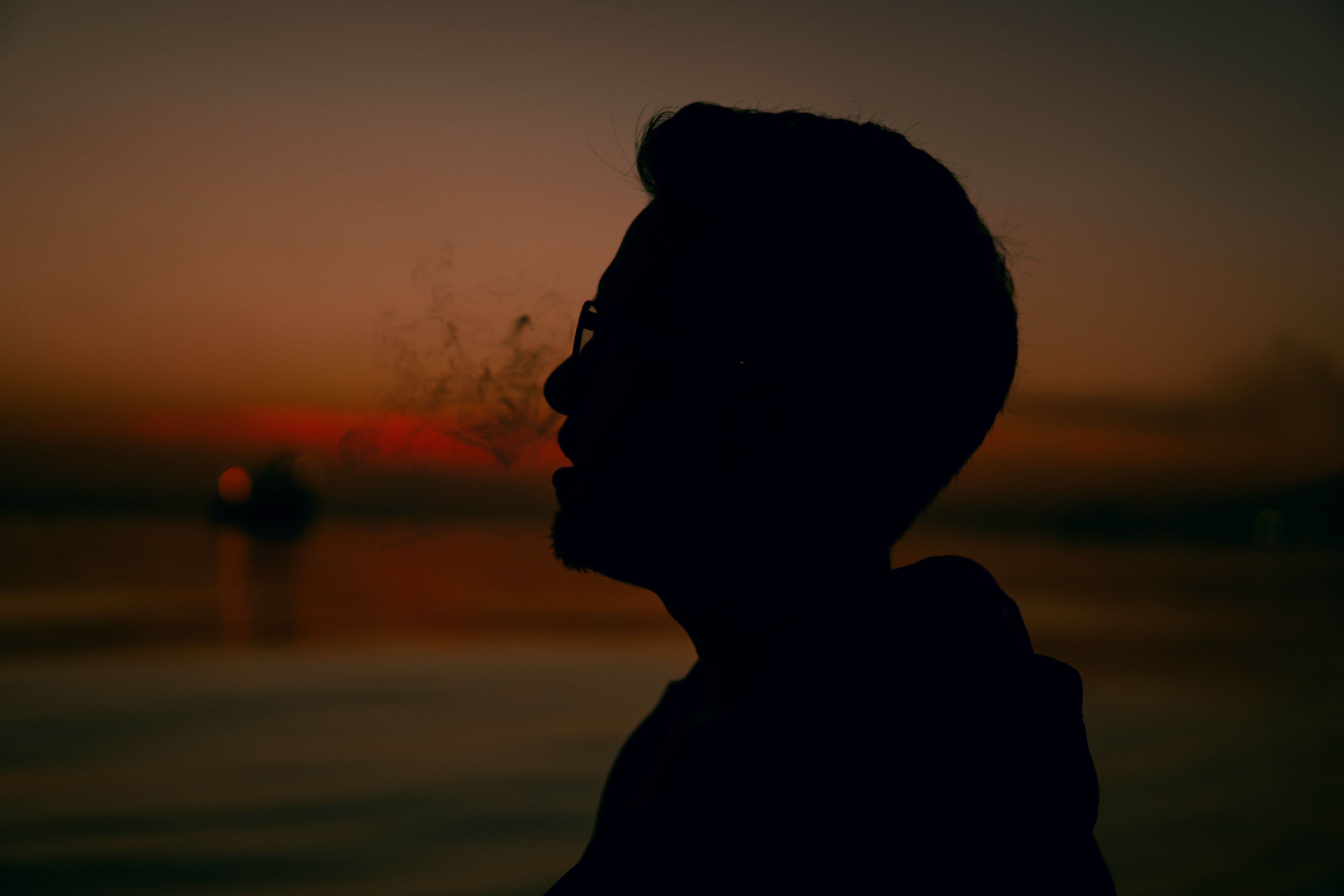 Silhouette of Man on Lake Shore at Sunset · Free Stock Photo