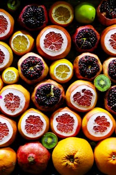 Colorful display of sliced citrus and pomegranate fruits showcasing freshness and juiciness.