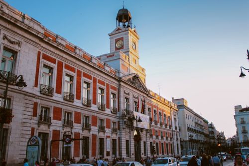 Free View of the iconic Puerta del Sol clock tower in Madrid, Spain, during dusk. Stock Photo
