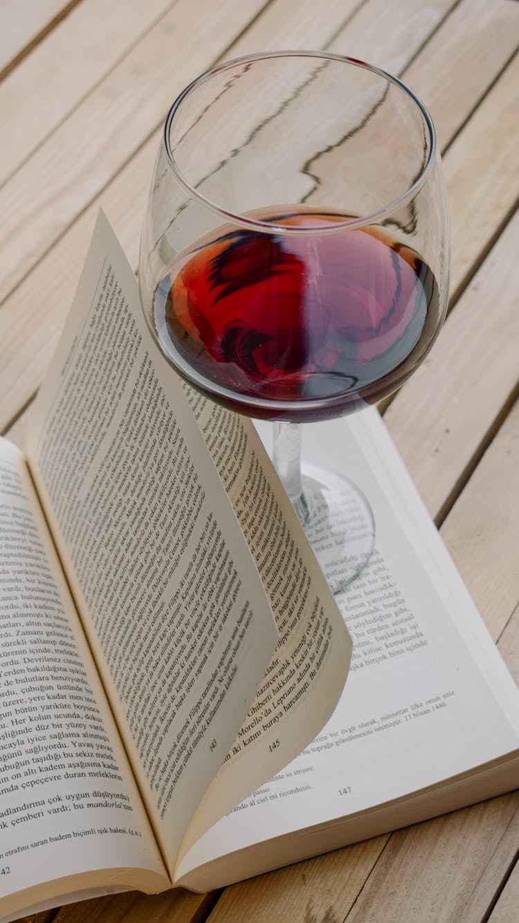 A Glass Of Red Wine On A Book 