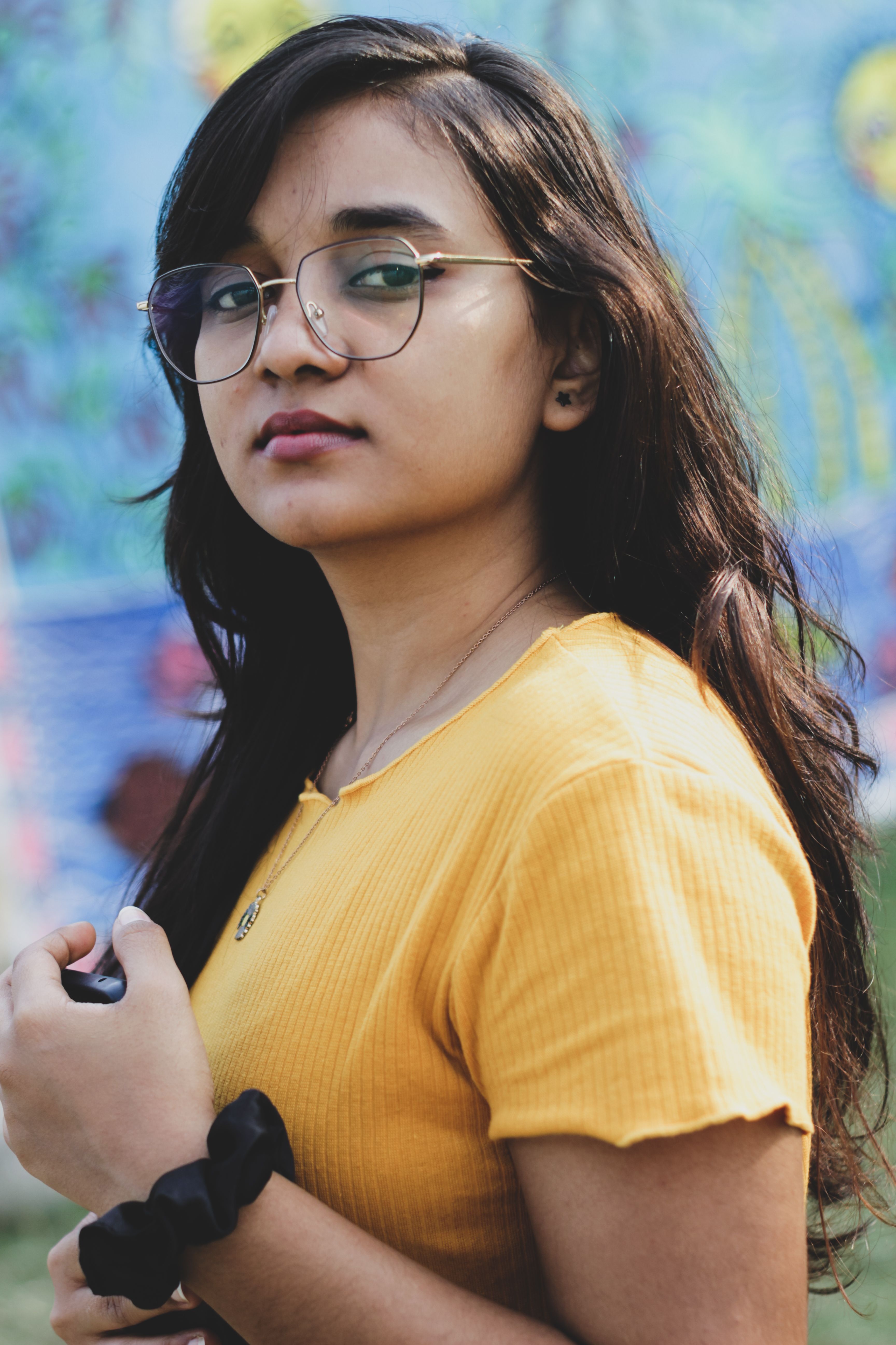 Portrait of a South Asian teenager in a yellow shirt standing outdoors in Patna, India.