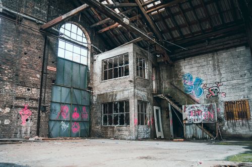 Free Explore this decaying warehouse with vibrant graffiti art covering its walls. Stock Photo