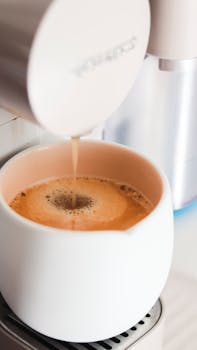 A close-up of coffee being brewed into a cup using a modern coffee machine.