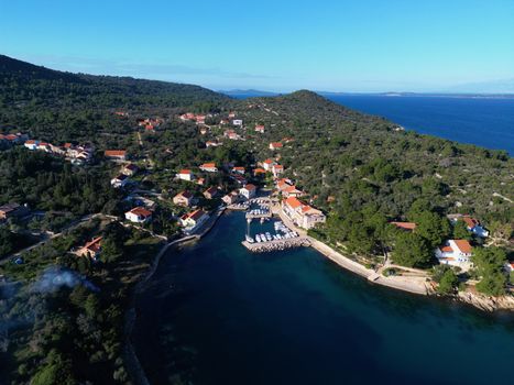 Drone shot of scenic Veli Iž village with lush greenery and coastline in Croatia.