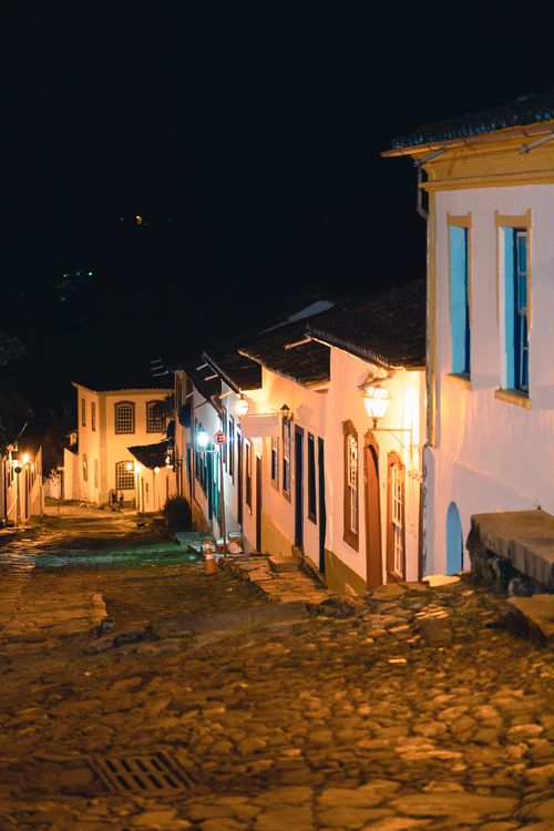 Free Cobblestone street of Tiradentes, MG, Brazil at night with illuminated colonial buildings. Stock Photo