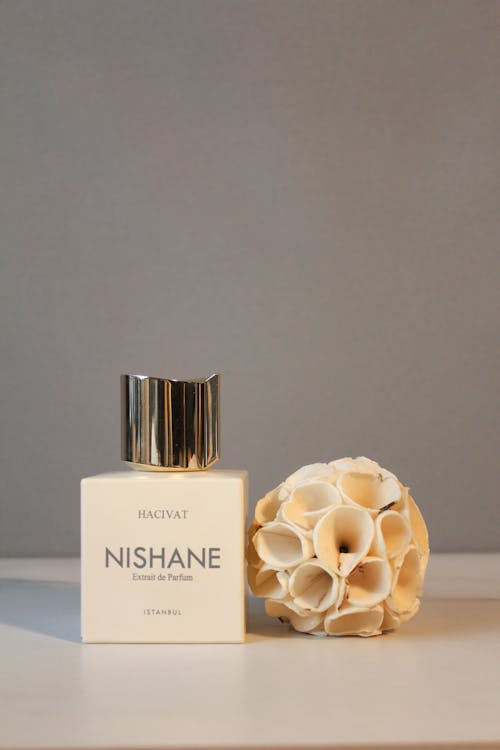 Bottle of Perfume next to Artificial Dried Lotus