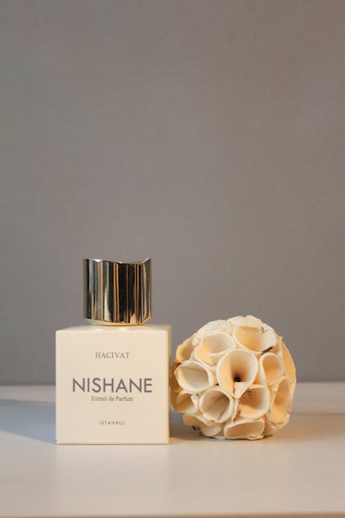 Free Bottle of Perfume next to Artificial Dried Lotus Stock Photo