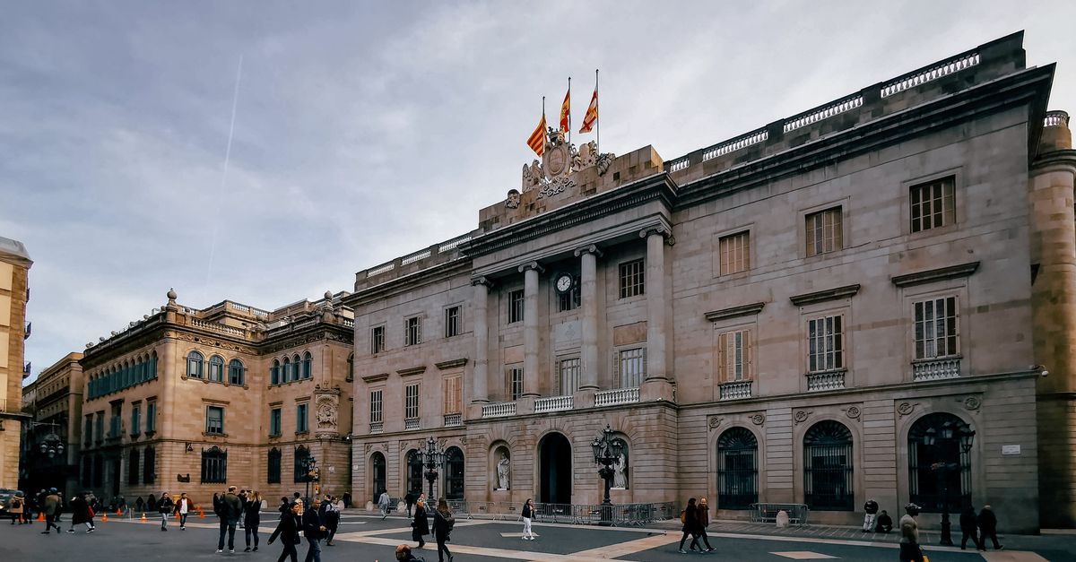 Explora una bulliciosa plaza pública en España, rodeada de edificios históricos bajo un cielo nublado.