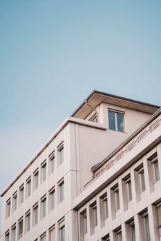 Low angle view of a modern building with windows against a clear blue sky.