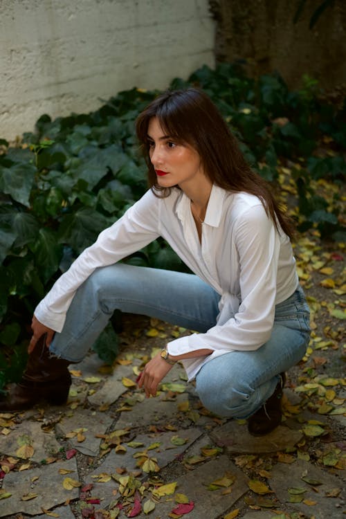 A Woman in White Long Sleeves and Denim Jeans Posing