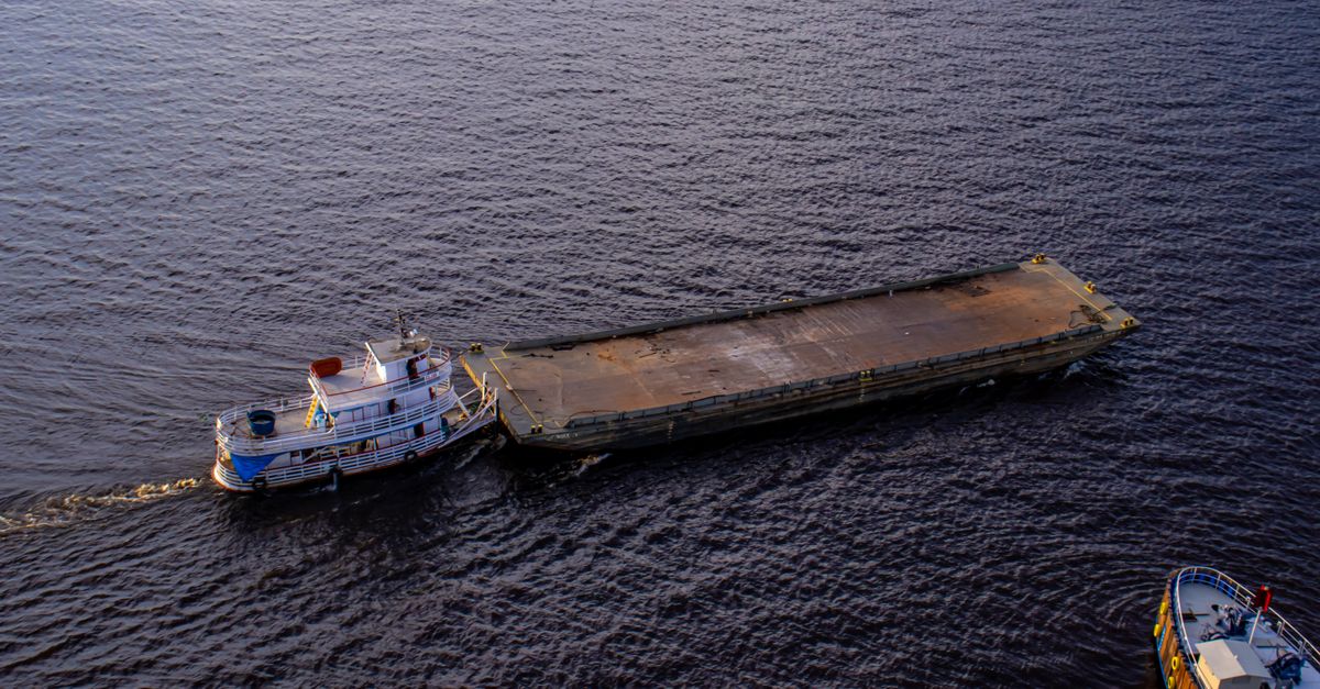 Aerial shot of a tugboat towing a barge on the river in Manaus, Brasil.