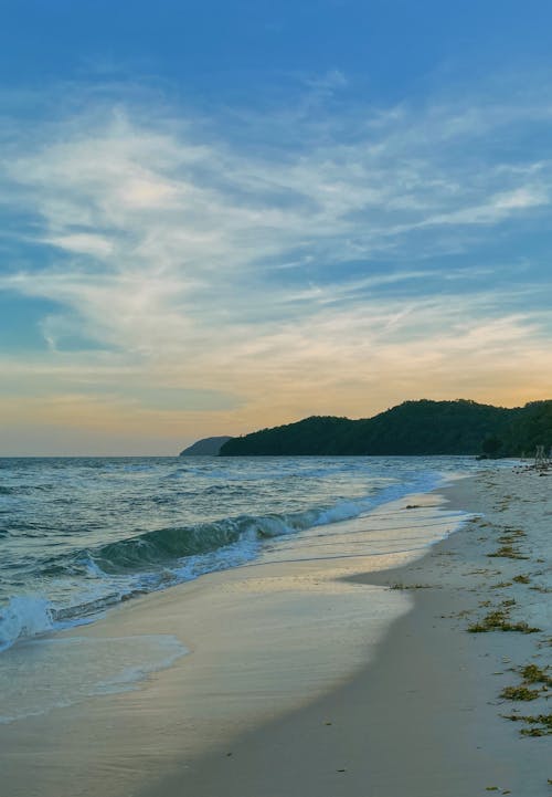 Waves Splashing on Sand Beach on Sunset