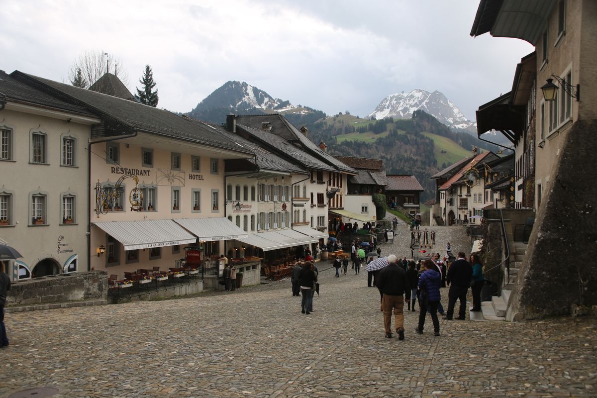 Strada principala pietruita din Gruyeres, cu Alpii in fundal
