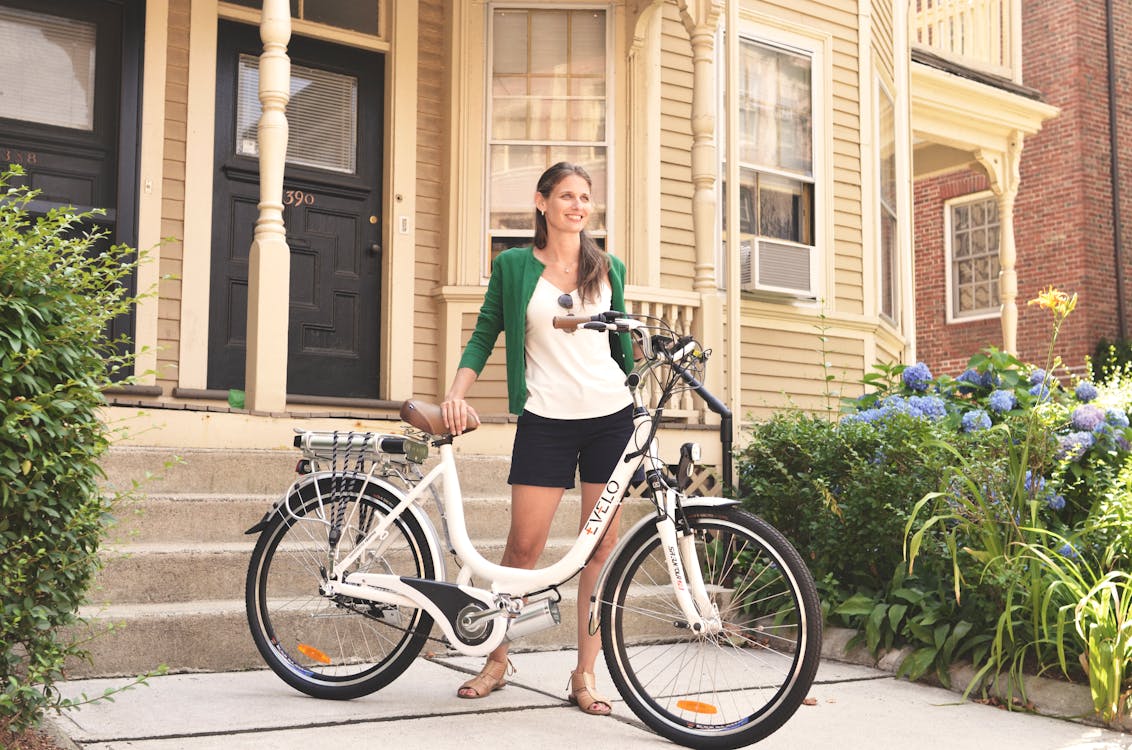 Free A Woman in a Green Cardigan Holding an Electric Bike Stock Photo