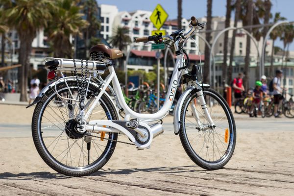 White electric bike parked on a beachside path