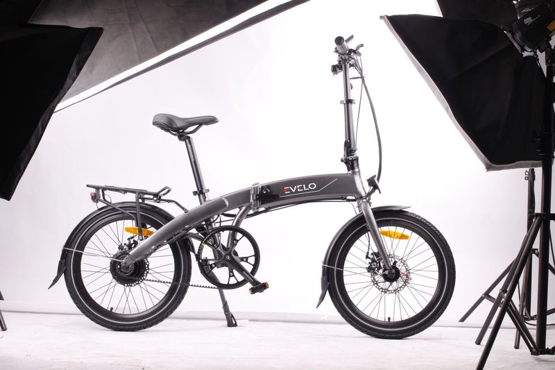 Modern foldable black electric bicycle displayed in a studio environment