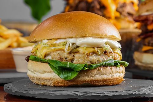 Free Mouth-watering gourmet burger with fresh toppings, perfect for fast food lovers. Stock Photo