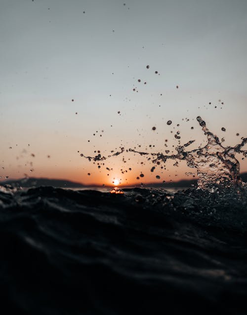 Close-up of Splashing Water in the Sea on the Background of a Sunset Sky 