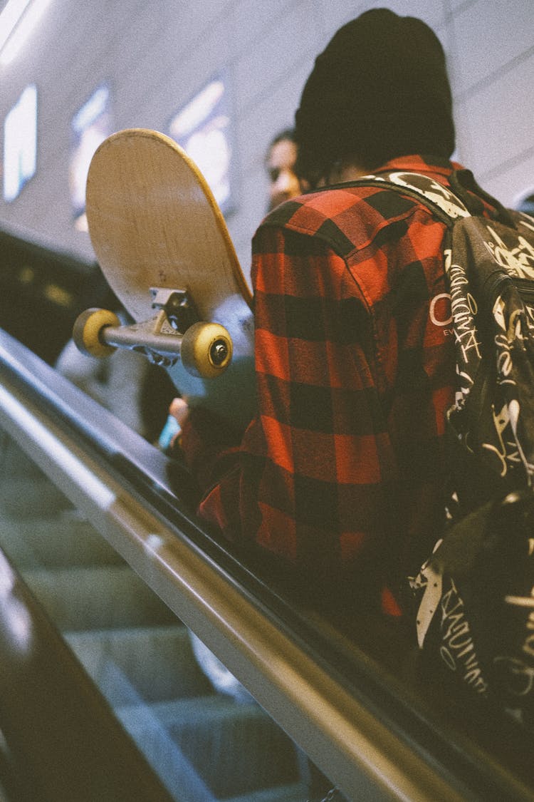 Guy With Skateboard On Escalator