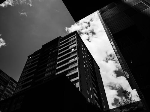 Free A striking black and white view of urban skyscrapers with dramatic lighting and architectural detail. Stock Photo