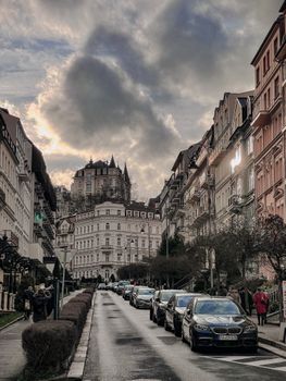 Scenic old town street surrounded by historic facades under a dramatic cloudy sky.