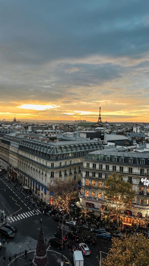 Free Stunning view of Paris cityscape featuring Eiffel Tower and beautiful sunset skies, urban elegance at its best. Stock Photo