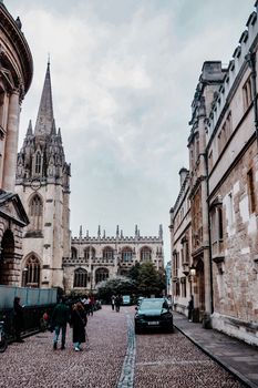 Captivating view of a historic city street lined with gothic architecture, showcasing a church with a spire.