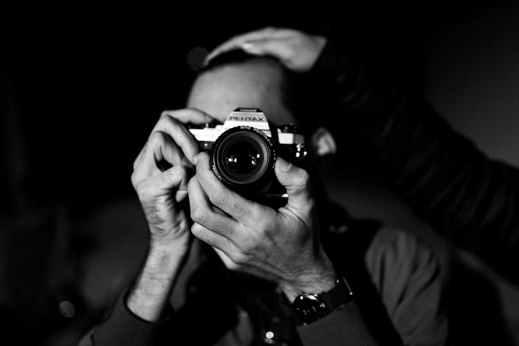 Grayscale Photo Of Person Looking Through A Camera