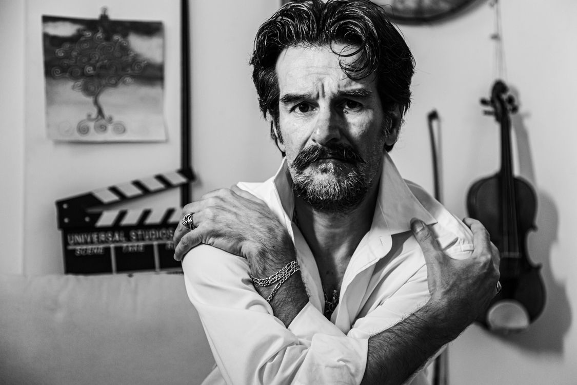 Free Emotionally compelling black and white portrait of a man with a violin in the background. Stock Photo