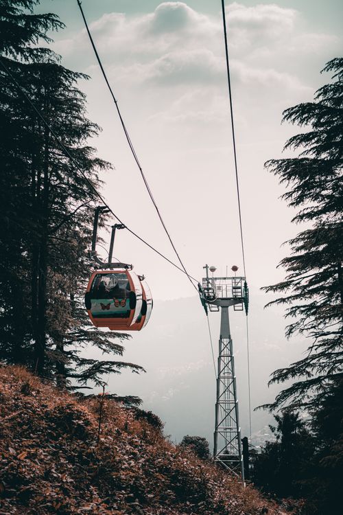 Free A cable car traveling over a lush mountainous region on a clear day, capturing the essence of natural beauty and adventure. Stock Photo